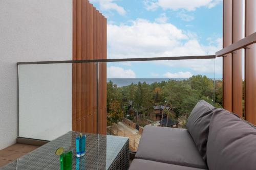 a balcony with a table and a large window at Apartments Mazowiecka Pobierowo by Renters in Pobierowo