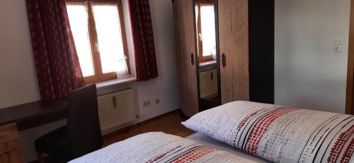 a bedroom with two windows and a bed and a desk at Haus Untersberg in Bad Reichenhall