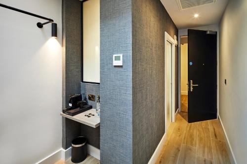 ein Bad mit einem Waschbecken und einem Wandspiegel in der Unterkunft Handel's Hotel in Dublin