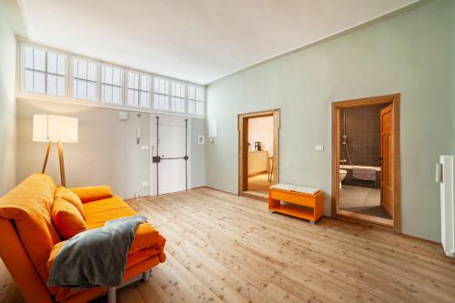 a living room with an orange couch and a wooden floor at Lauben 75 in Merano
