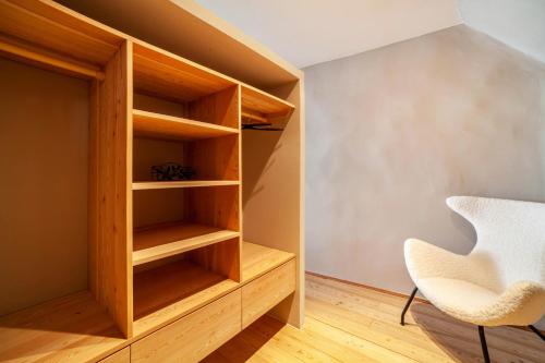 a room with wooden shelves and a white chair at Lauben 75 in Merano