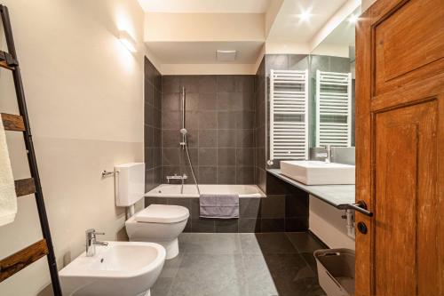 a bathroom with a toilet and a sink and a tub at Lauben 75 in Merano