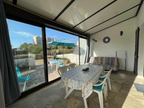 un patio avec une table, des chaises et un parasol dans l'établissement Maison 3 pièces, 6 couchages, plage à 200m, jardin clos, parking privé, tout confort, Saint-Jean-de-Monts - FR-1-224C-541, à Saint-Jean-de-Monts