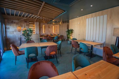 a restaurant with wooden tables and colorful chairs at OIKOS APARTAMENTOS TURÍSTICOS in Monesterio