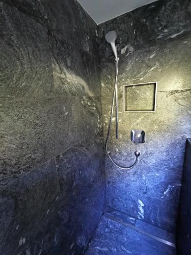a bathroom with a shower with a hose in a room at Gschlössl, Ferienhaus in Rauris