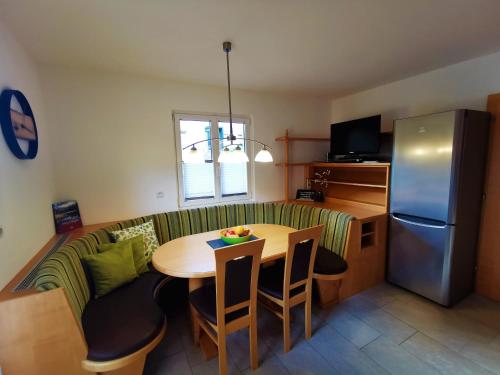 a kitchen and dining room with a table and a refrigerator at Gschlössl, Ferienhaus in Rauris