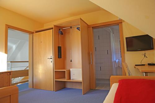 a bathroom with a shower and a television in a room at Haus der Begegnung in Gosau