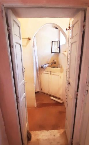 an open door leading to a bathroom with a sink at Maison d'Hôtes Irocha in Tisselday