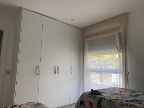 a bedroom with white cabinets and a bed and a window at Casa hugo olite in Olite