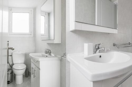 a white bathroom with a sink and a toilet at Magnificent 2BR Apartment in Marousi by UPSTREET in Athens