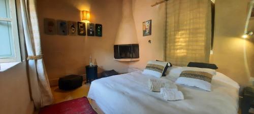 a bedroom with a bed with white sheets and pillows at Maison d'Hôtes Irocha in Tisselday