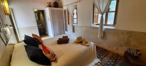 Un dormitorio con una cama con sombreros. en Maison d'Hôtes Irocha, en Tisseldeï