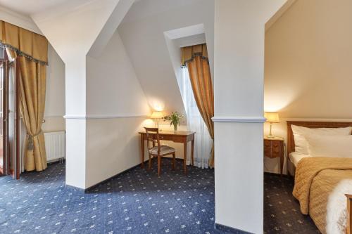 a hotel room with a bed and a desk at Spa Hotel Villa Ritter in Karlovy Vary