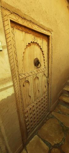 a wooden door with a handle on a wall at Maison d'Hôtes Irocha in Tisselday