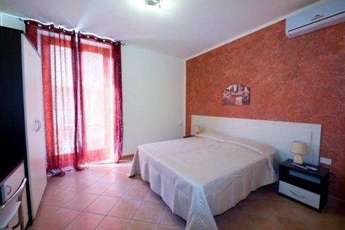 a bedroom with a bed and a red wall at Albachiara holidays in Marsala