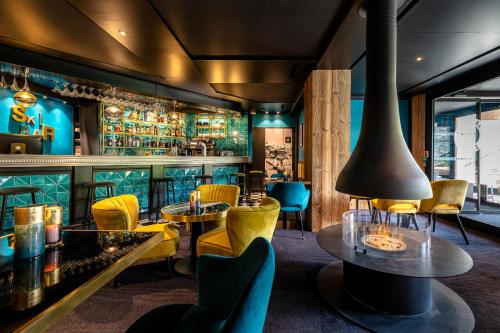a restaurant with yellow chairs and tables and a bar at Fahrenheit Seven Courchevel in Courchevel