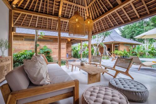 an outdoor living room with a couch and a table at Kaju Apartment by Hombali in Canggu