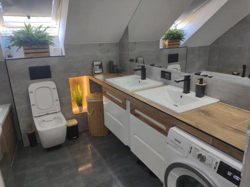 a bathroom with two sinks and a washing machine at Pokoje Gościnne U Bosmana in Dźwirzyno