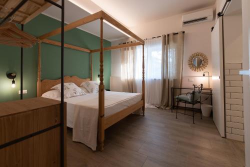 1 dormitorio con cama con dosel y pared verde en Tenuta Tre Gemme a mare - Suite Salvia, en Pescara