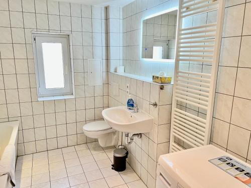 a white bathroom with a sink and a toilet at Meißner Elb-Domizil in Meißen