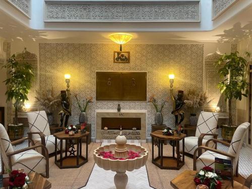 a living room with a fireplace and a tv at Riad Wazani Square & SPA in Marrakech