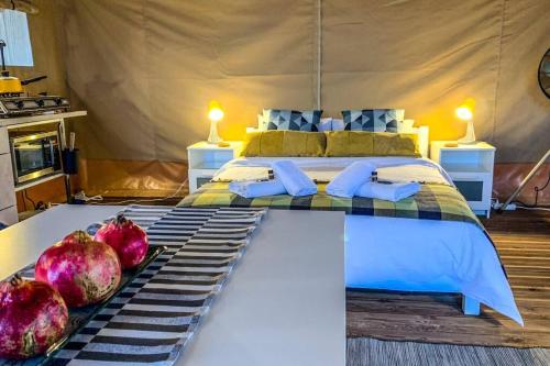 1 dormitorio con 1 cama con granadas en el suelo en African Safari Canvas Lodge Tent Sea View, en Kranidi