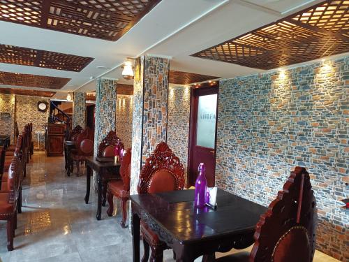 a dining room with tables and chairs and brick walls at HYDERS PARK- THE LUXURY HOTEL in Kodaikānāl