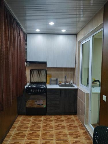 uma cozinha com um lavatório e um fogão forno superior em Квартира 2-ух комнатная в центре города em Fergana