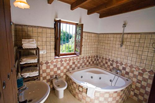 a bathroom with a tub and a toilet and a sink at Villa El Lagar Rocabella in El Chorro