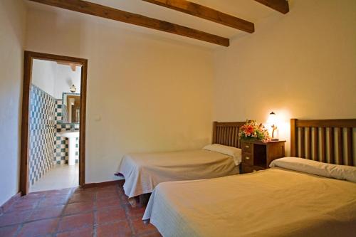 a bedroom with two beds and a hallway with a mirror at Villa El Lagar Rocabella in El Chorro