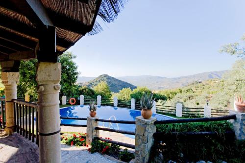 a swimming pool with a fence and potted plants at Villa El Lagar Rocabella in El Chorro