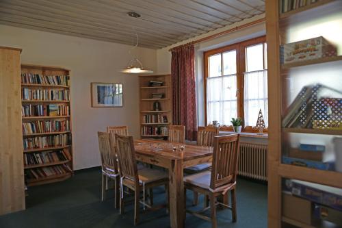 een eetkamer met een houten tafel en stoelen bij Haus der Begegnung in Gosau