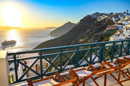 a balcony with chairs and a view of the ocean at DELION VIEW HOTEL in Fira
