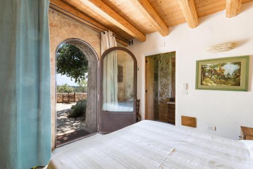1 dormitorio con 1 cama y puerta abierta en Villa Elaion by BarbarHouse, en Marina di Pescoluse