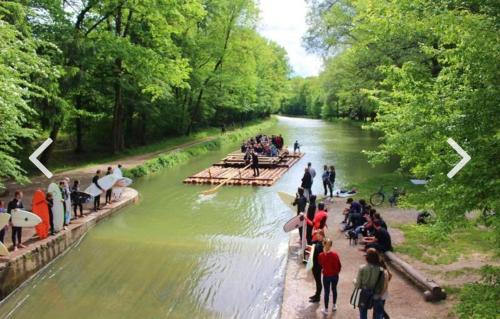 Un groupe de personnes sur un radeau dans une rivière dans l'établissement AllYouNeed Oktoberfest camping, à Munich