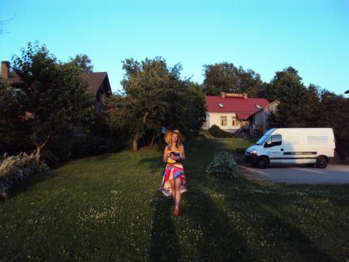 Une femme en robe marchant dans l'herbe dans l'établissement Saule, à Talsi