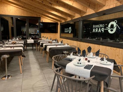 a dining room with tables and chairs and a television at Càmping Organyà Park in Organyà