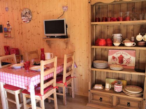 une salle à manger avec une table et une télévision dans l'établissement Charmant studio à Vars Les Claux, proche commodités et pistes, balcon en rez-de-chaussée - FR-1-330B-130, à Vars