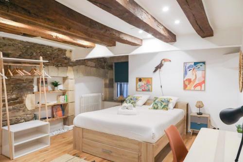 a bedroom with a large white bed and a stone wall at Esprit Feydeau- 2 chambres en bail mobilité in Nantes