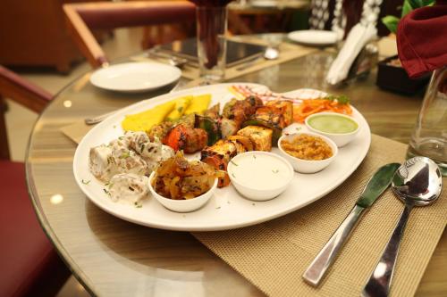 a plate of food on a glass table at THE HOTEL PARADISE in Gorakhpur