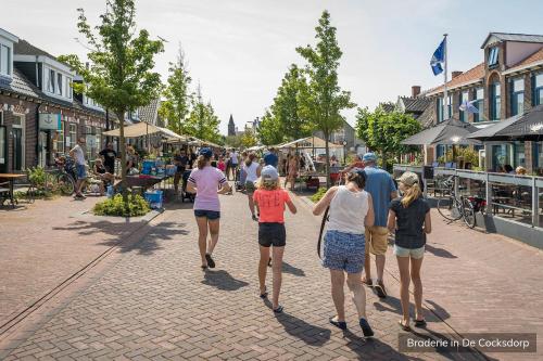 a group of people walking down a street at Hotel Molenbos Texel in De Cocksdorp