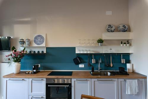 a kitchen with blue and white walls and a sink at Tenuta Tre Gemme a Mare - Suite Blu Vista mare in Pescara