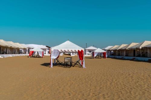 a beach with tents and chairs on the sand at Marina Dessert Camp in Sām