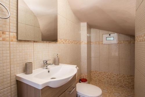 a bathroom with a sink and a toilet at Kalypso Sea View Villa in Koskinou