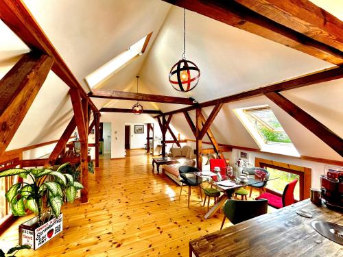 a large living room with wooden beams and a dining room at Historisches Retro Loft 120m2 + Garten & Seenähe in Schwielowsee