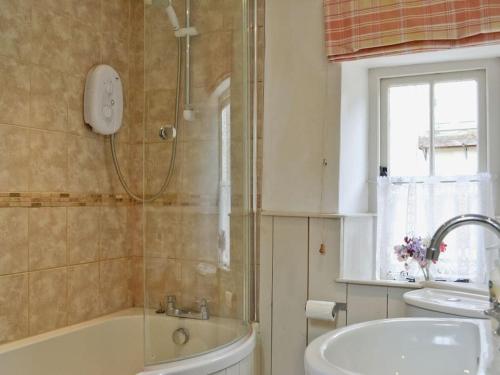 y baño con ducha, bañera y lavamanos. en Fern Dale Cottage, en Stockland