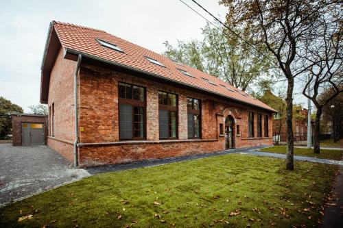 a brick building with a grass yard in front of it at City Housing Genk in Genk