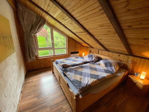 a bed in a room with a wooden ceiling at EXTERTAL-FERIENPARK - Premium-Ferienhaus Sonnenhügel #36 in Extertal
