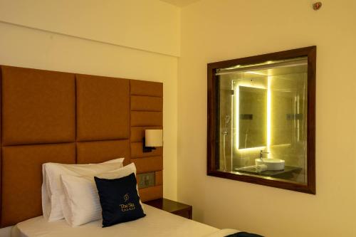 a bedroom with a bed with a mirror and a sink at Mastiff Grand The Sia Palace Suites & Banquets, Khopoli, Near Imagica in Khopoli