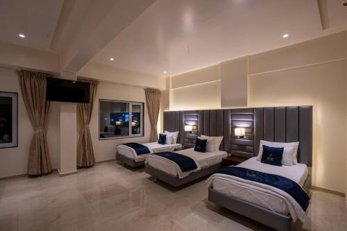 a hotel room with two beds and a flat screen tv at Mastiff Grand The Sia Palace Suites & Banquets, Khopoli, Near Imagica in Khopoli